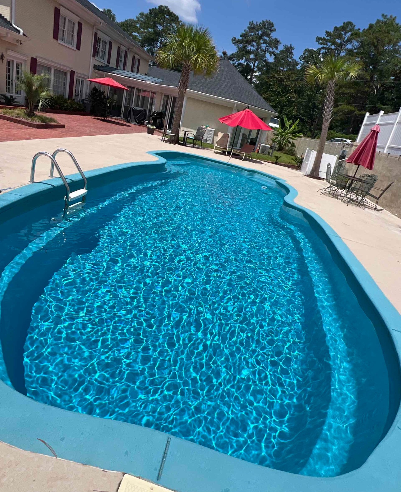 Clear curved residential pool with bright blue water.