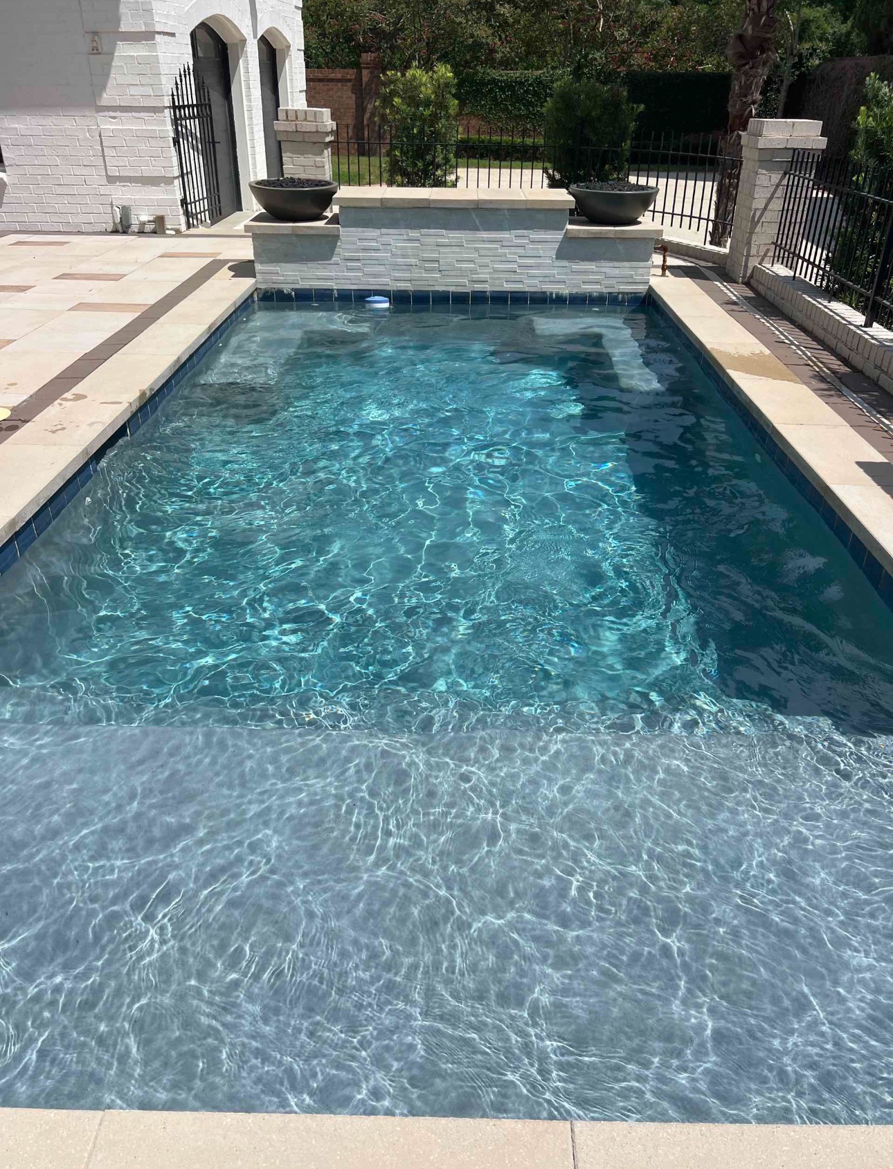 Clear residential pool with light stone coping.